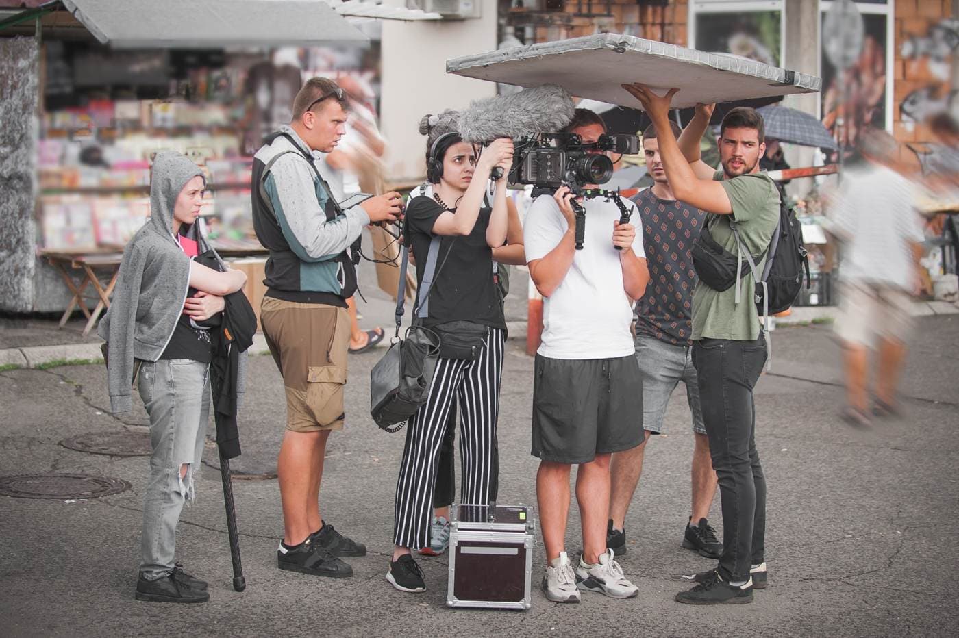 A young film crew shooting on a street, with camera and boom